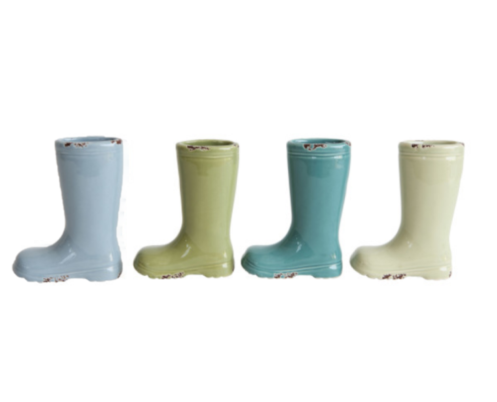 A set of four small stoneware vases in the shape of boots with distressed finishes and various colors.